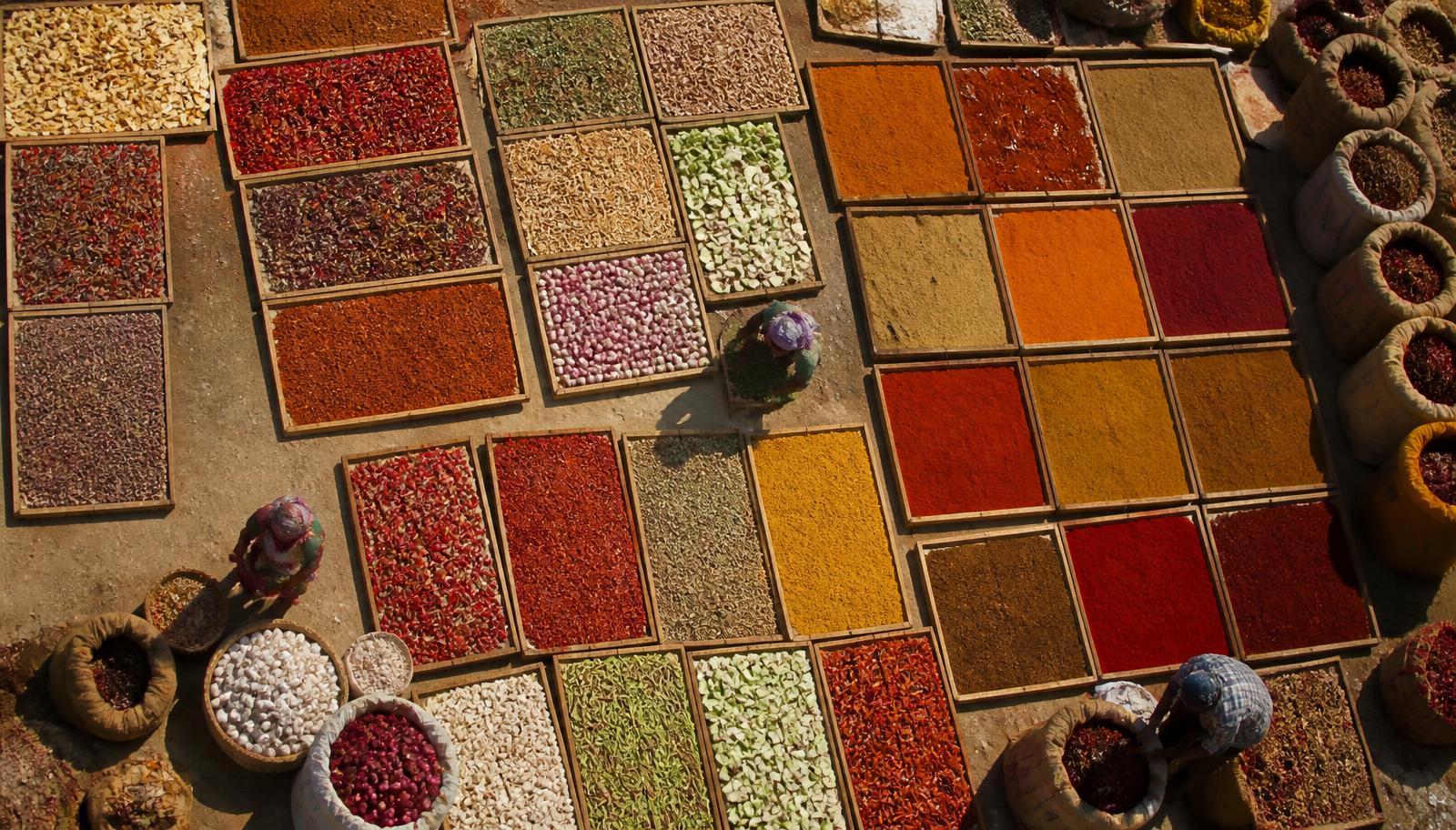 Trays of drying spices and dehydrated produce in a sun yard